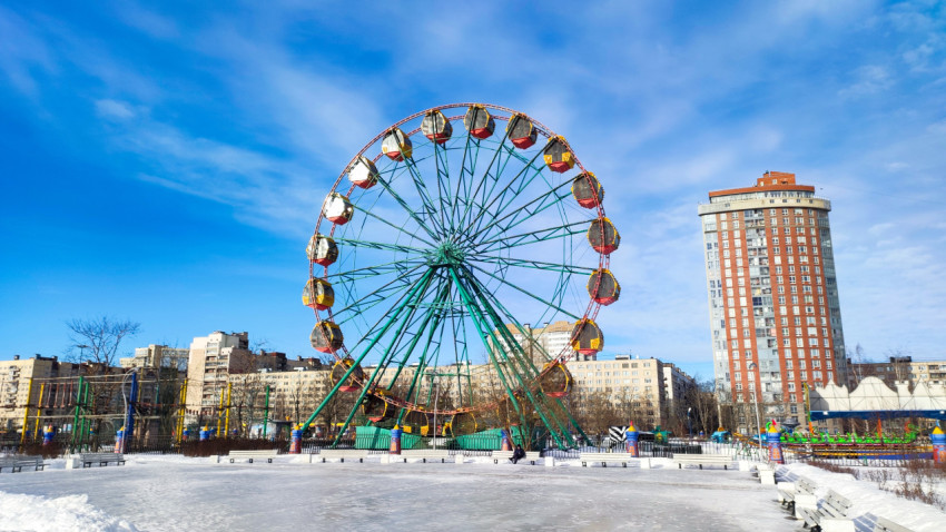 Колесо обозрения на фоне жилой застройки зимой