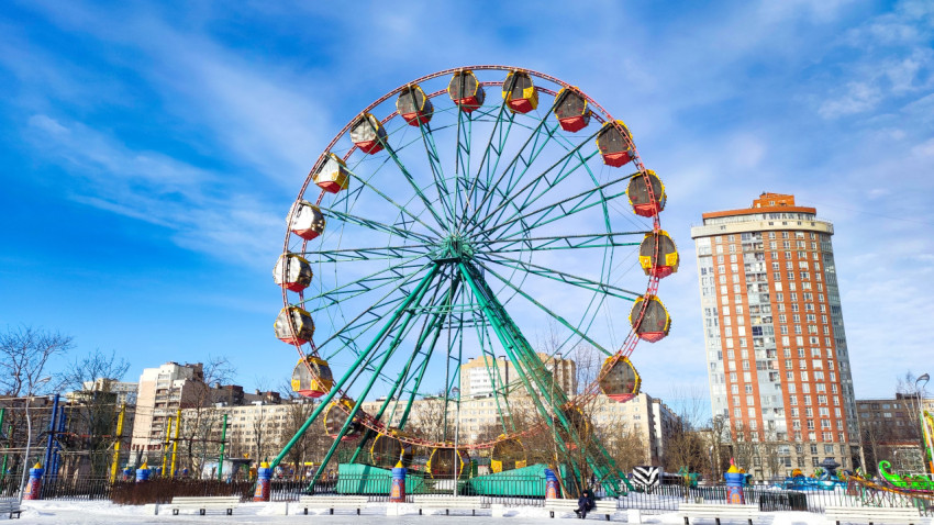 Колесо обозрения и башенное жилое здание зимой