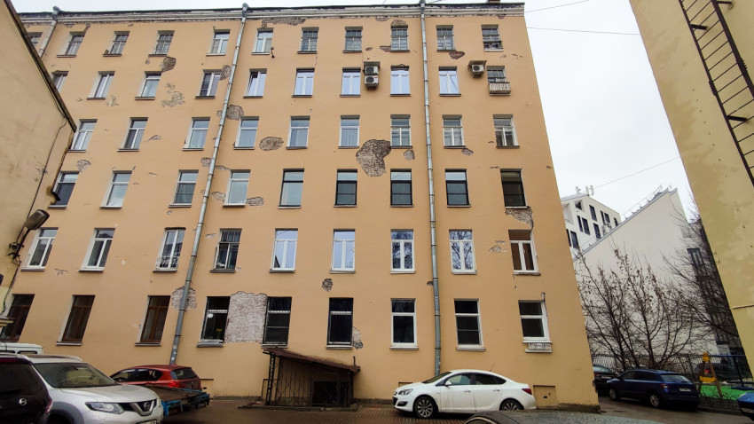 Фасад жилого дома на Корпусной улице с повреждённой штукатуркой