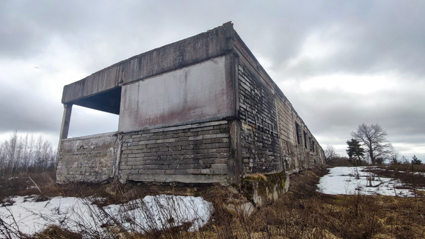 Заброшенное промышленное здание из бетона и кирпича на фоне зимнего ландшафта