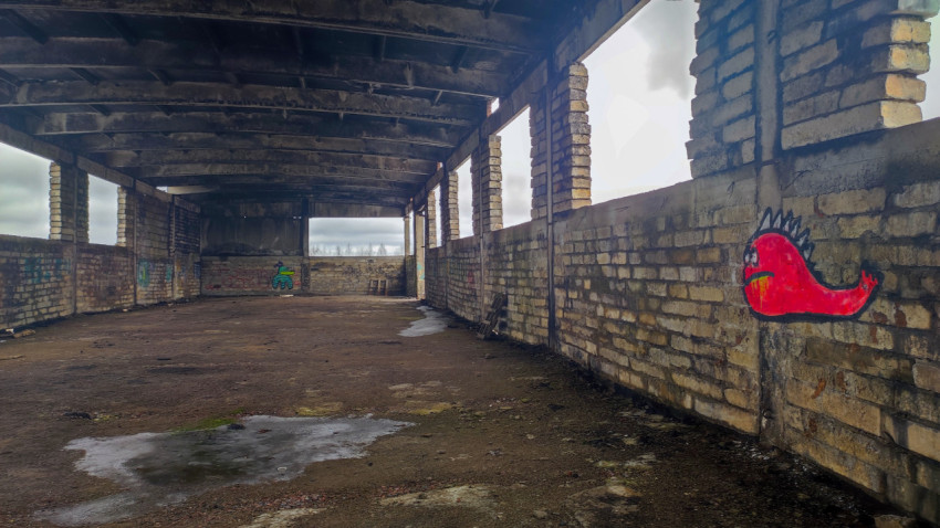 Внутреннее пространство заброшенного кирпичного цеха с граффити