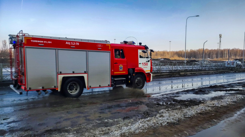 Пожарная машина в движении на загородной дороге после осадков