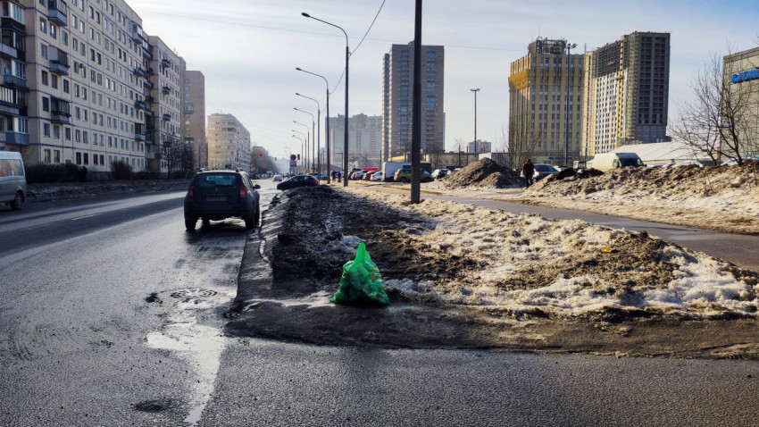 Пакет мусора на обочине городской дороги