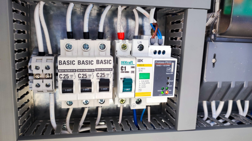 Крупный план автоматических выключателей и контроллера в электрическом шкафу
