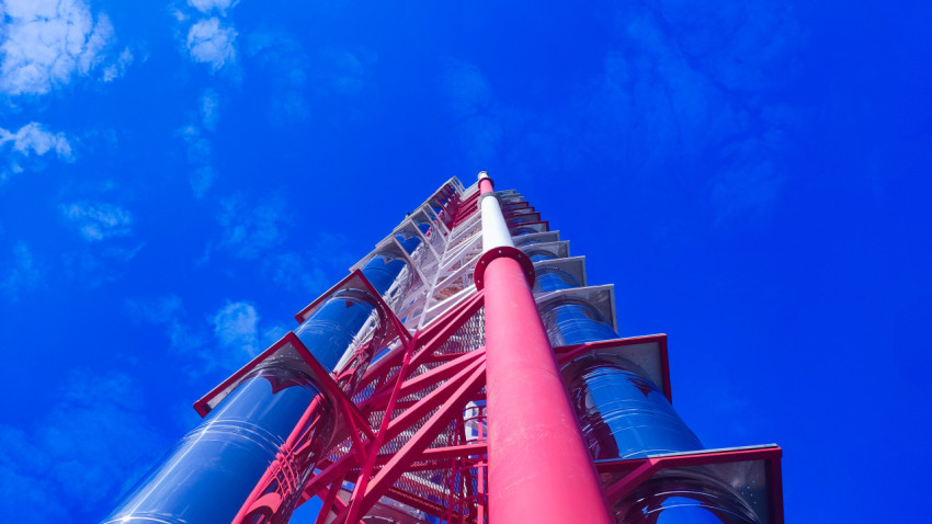 Металлическая дымовая труба котельной на фоне синего неба