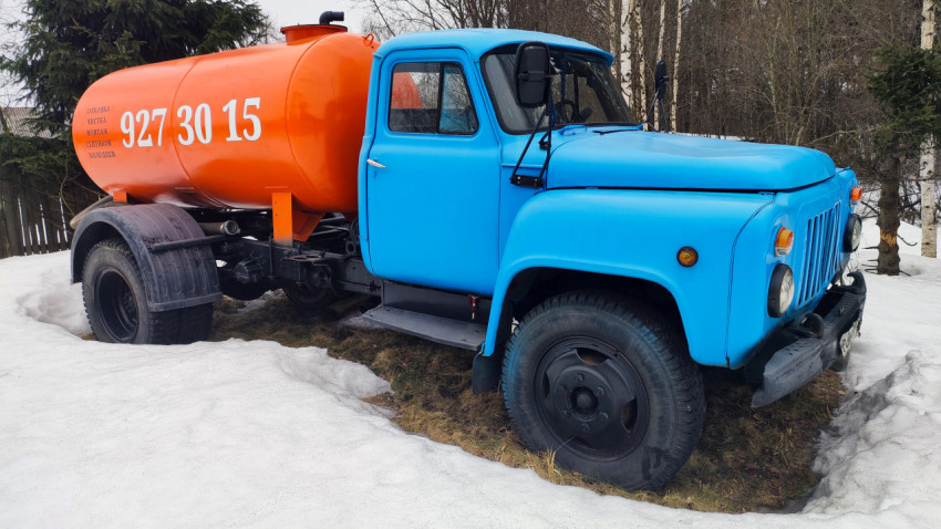 Синий советский грузовик с цистерной в зимнем лесу