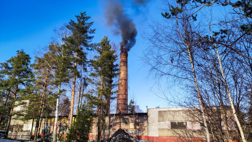 Промышленное предприятие с дымящей трубой зимой