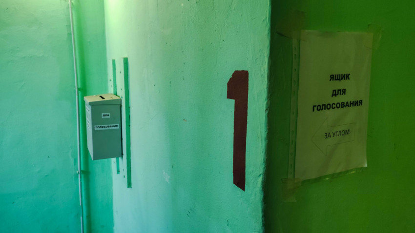 Зелёные стены подъезда и лист с указанием места голосования