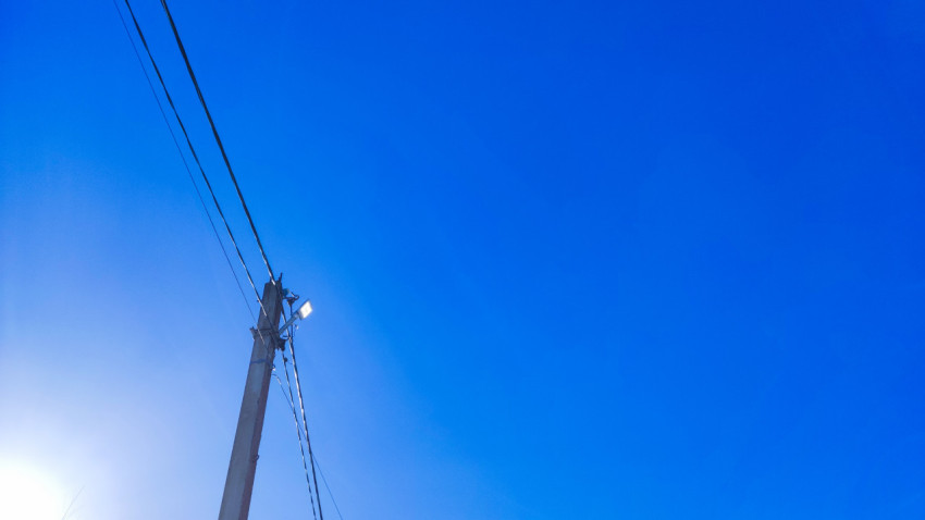 Электрический столб с линиями связи на фоне чистого неба