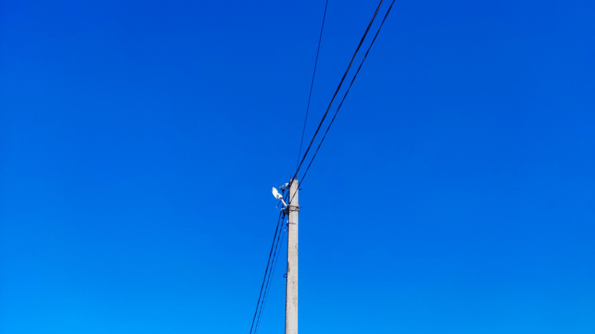 Электрический столб с линиями электропередачи на фоне зимнего неба