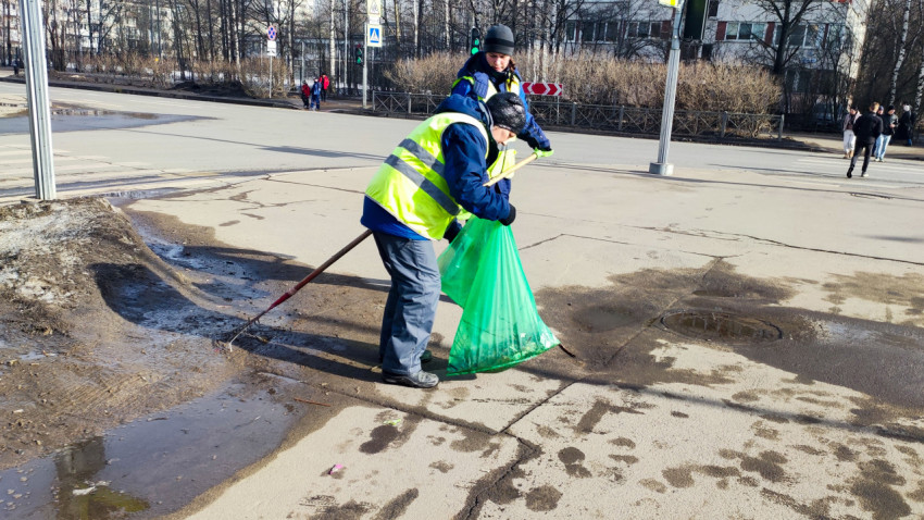 Работники коммунальных служб убирают мусор с дороги весной