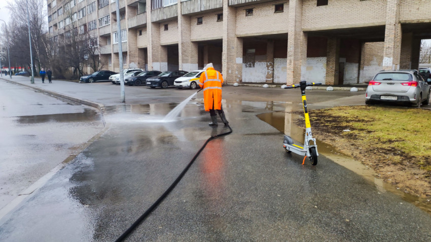 Коммунальный автомобиль с цистерной очищает проезжую часть