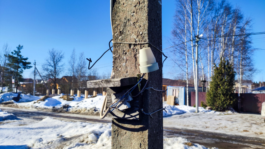 Нижняя часть опоры электросети с монтажным узлом и проводкой