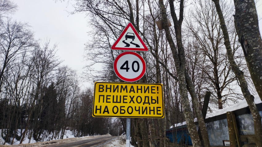 Знак «Внимание! Пешеходы на обочине» на заснеженной дороге