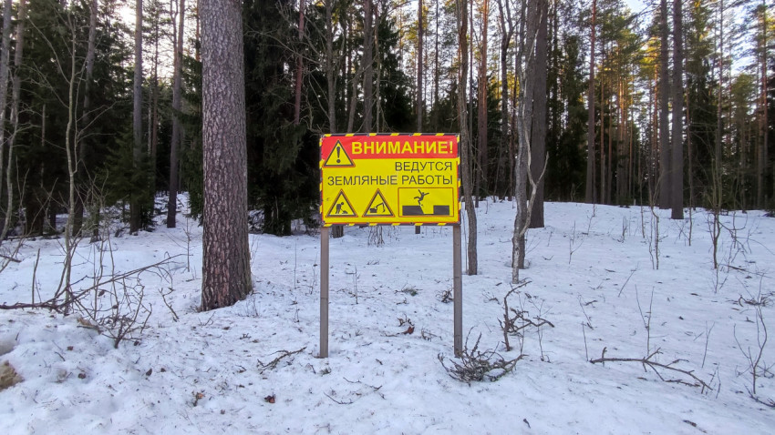 Информационный щит «Внимание! Ведутся земляные работы» в зимнем лесу