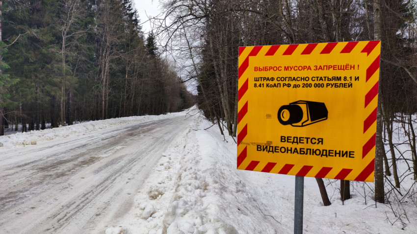 Предупреждающий знак о штрафе за выброс мусора вдоль зимней дороги