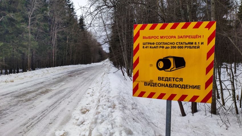 Дорожный знак о запрете выброса мусора и видеонаблюдении в зимнем лесу