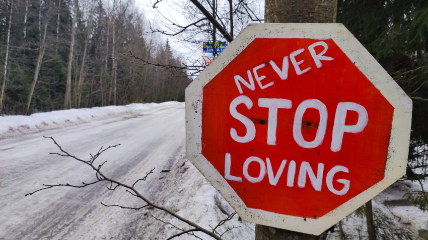 Красный знак «Never Stop Loving» крупным планом зимой