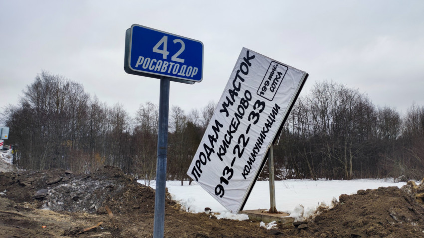 Рекламный щит и дорожный знак Росавтодор на трассе в Ленинградской области