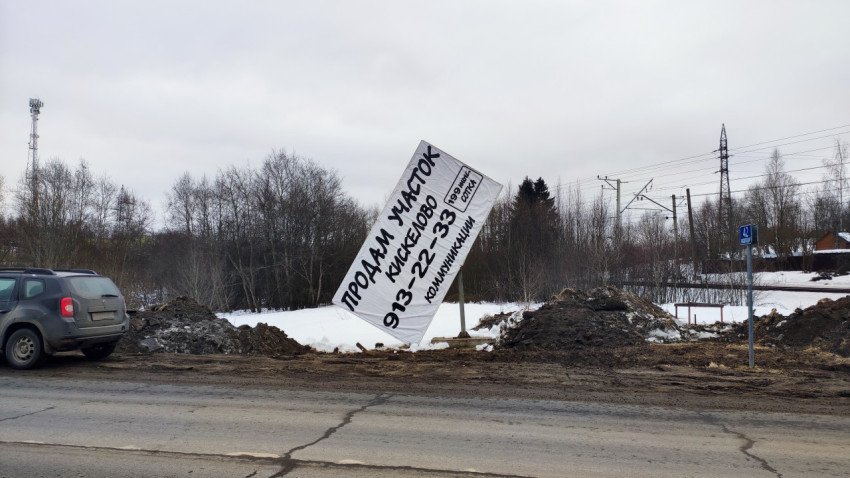 Рекламный баннер и автомобиль на загородной дороге зимой