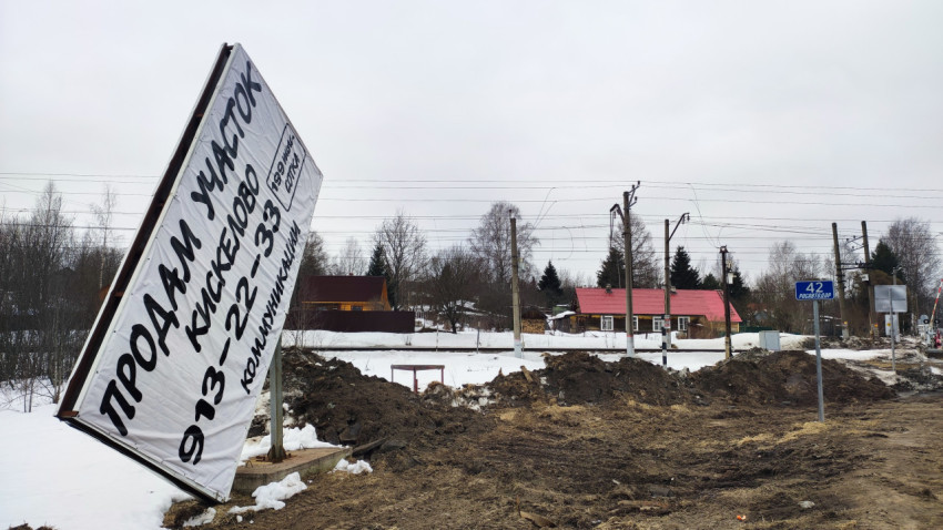 Баннер о продаже участка и знак Росавтодора у железнодорожной линии