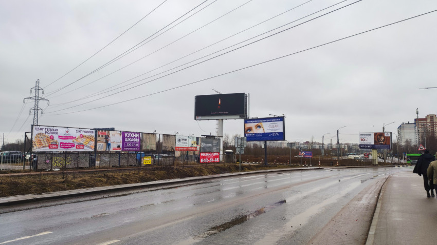 Улица с рекламными щитами и жилыми домами в пасмурный день