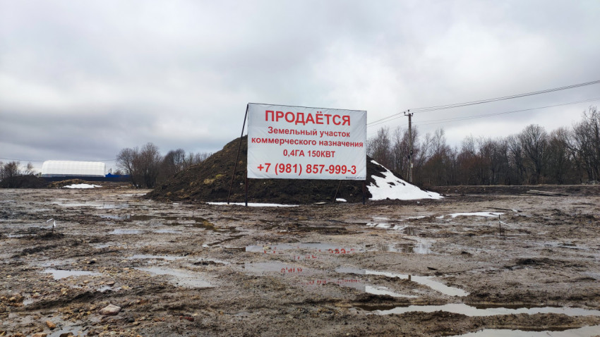 Участок с рекламным щитом о продаже и насыпью грунта