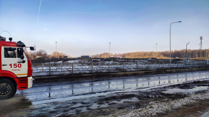 Пожарный автомобиль на фоне строительной площадки и зимнего ландшафта