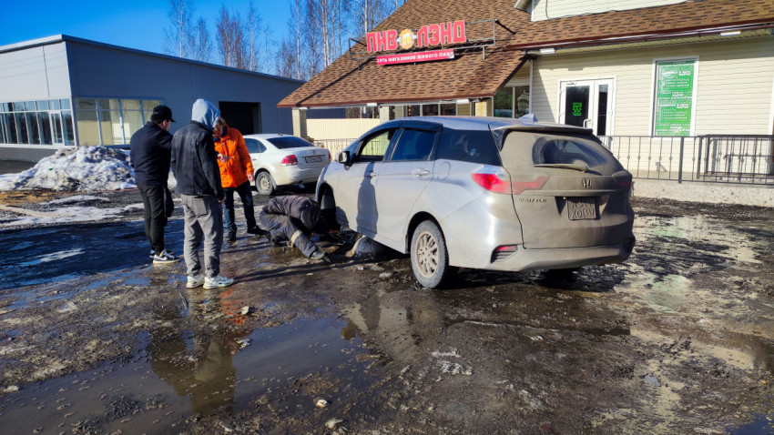 Люди ремонтируют автомобиль у магазина «Пиволэнд»