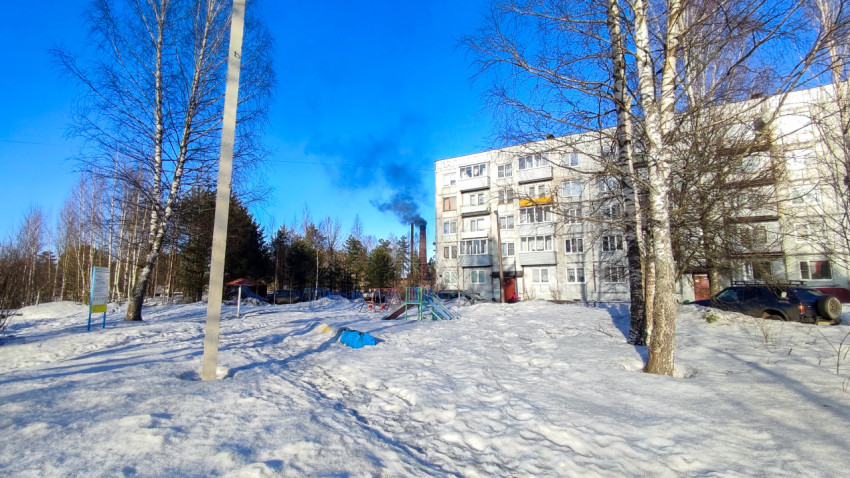 Детская площадка у пятиэтажного дома зимой