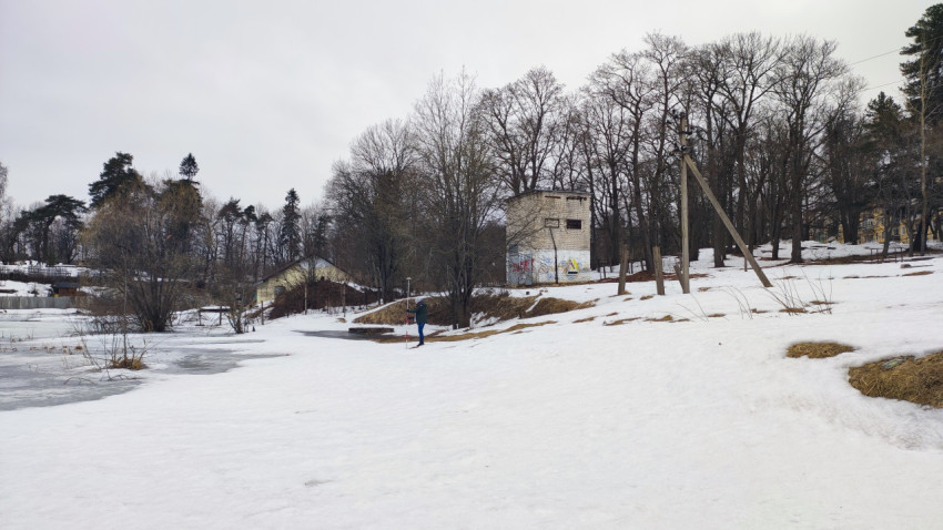 Человек с измерительным оборудованием у технического здания зимой