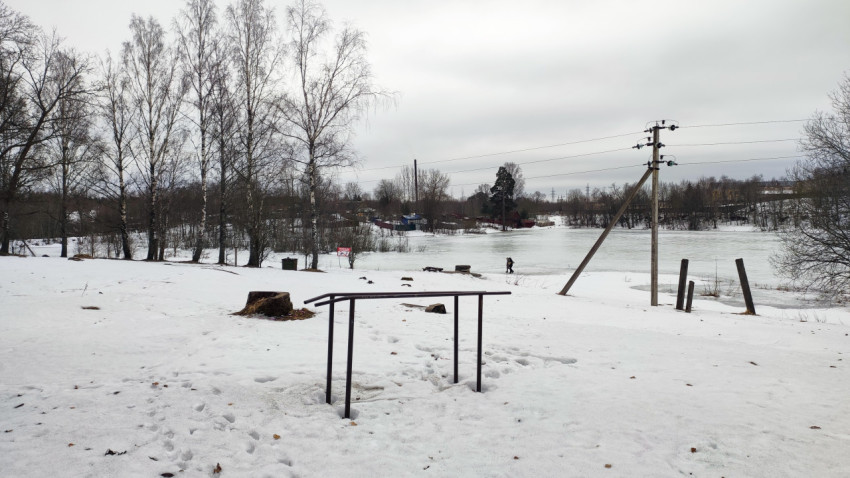 Замёрзшее озеро и заснеженный берег с металлическими конструкциями