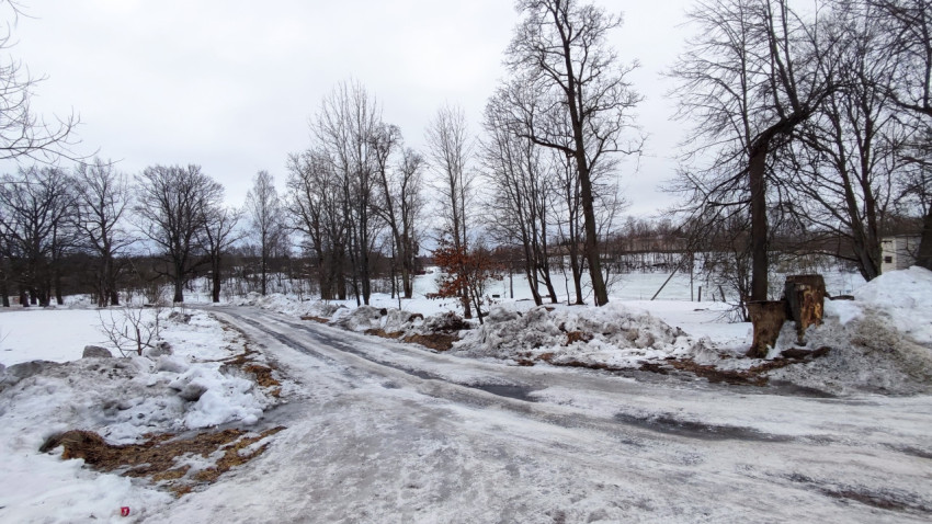 Зимняя дорога в парке с наледью и сугробами