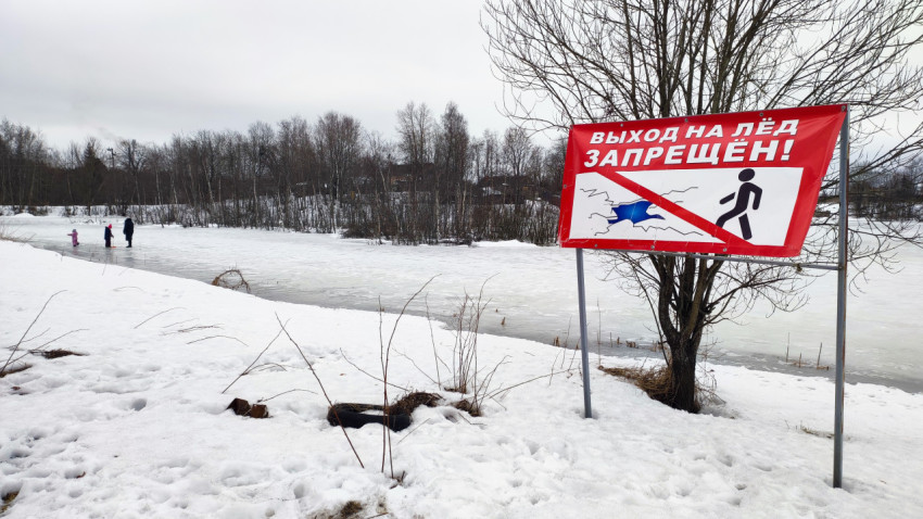 Предупреждающий плакат у зимнего пруда с людьми на льду
