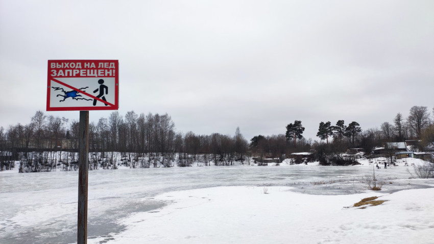 Знак «Выход на лёд запрещён» у замерзшего озера в зимний день