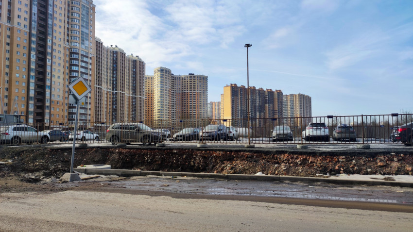 Многоэтажные жилые дома и парковка с машинами зимой