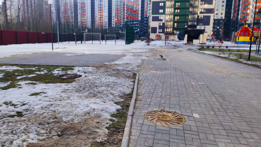 Дворовая дорожка с люком и тающим снегом