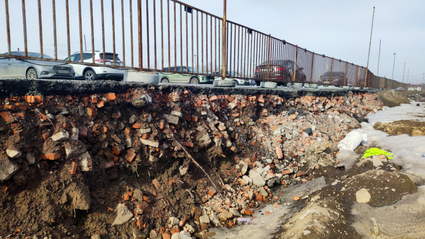 Городская обочина с остатками снега и кирпичным слоем грунта