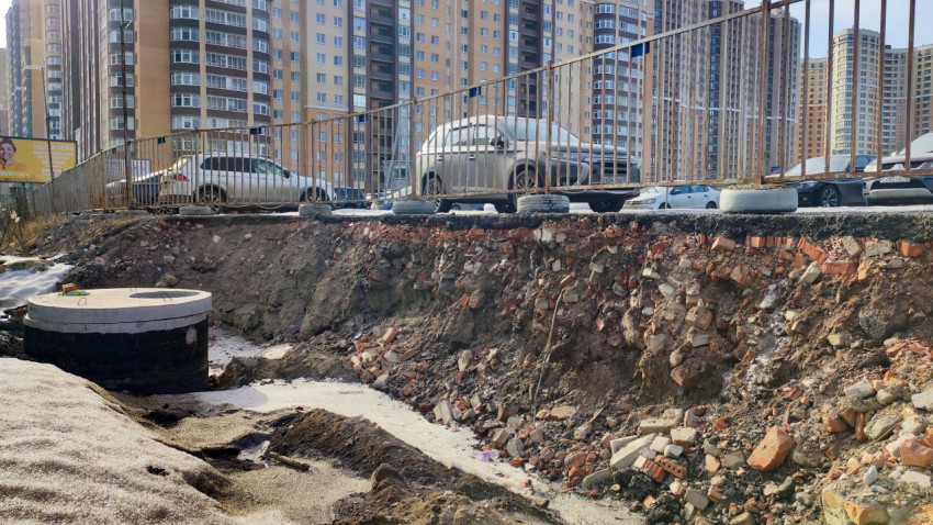 Оголённый слой грунта с кирпичными фрагментами вдоль парковки