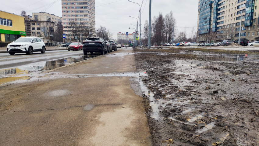 Городская улица с весенней грязью и лужами после таяния снега