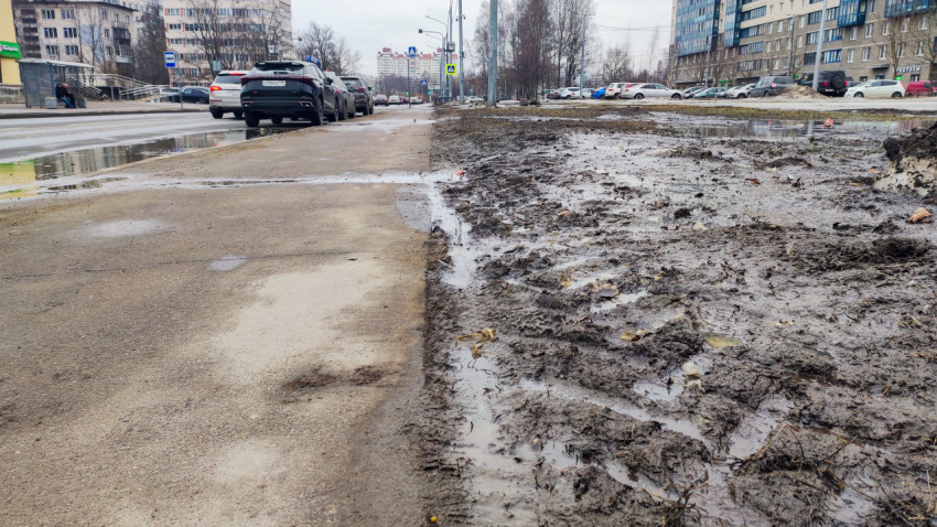 Весенняя улица с тротуаром и грязью после снега