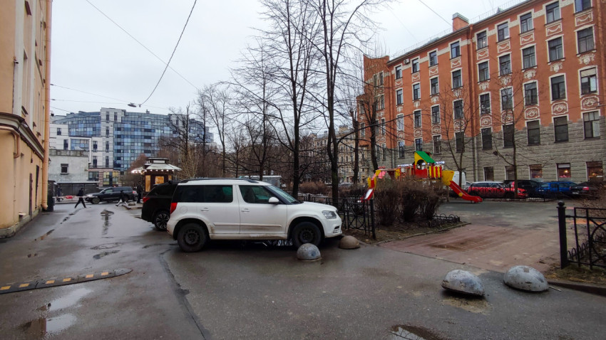 Парковка у детской площадки во дворе старого жилого квартала