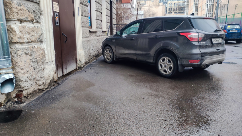 Автомобиль у входа в старое каменное здание