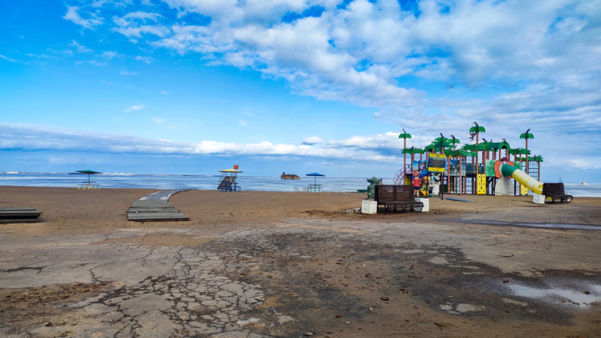 Пустынный городской пляж Кронштадта с настилом и детской площадкой