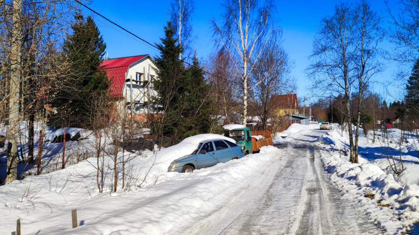 Загородная улица с припаркованным автомобилем и частными домами