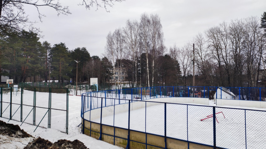 Спортивная площадка с ограждением и зимним снегом