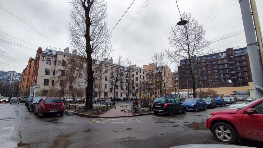 Двор жилого квартала с парковкой и деревьями зимой