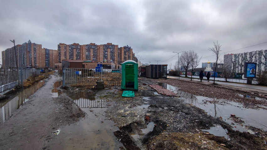 Городская сцена с биотуалетом на строительной площадке