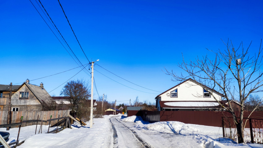 Сельская улица с деревянными домами зимой