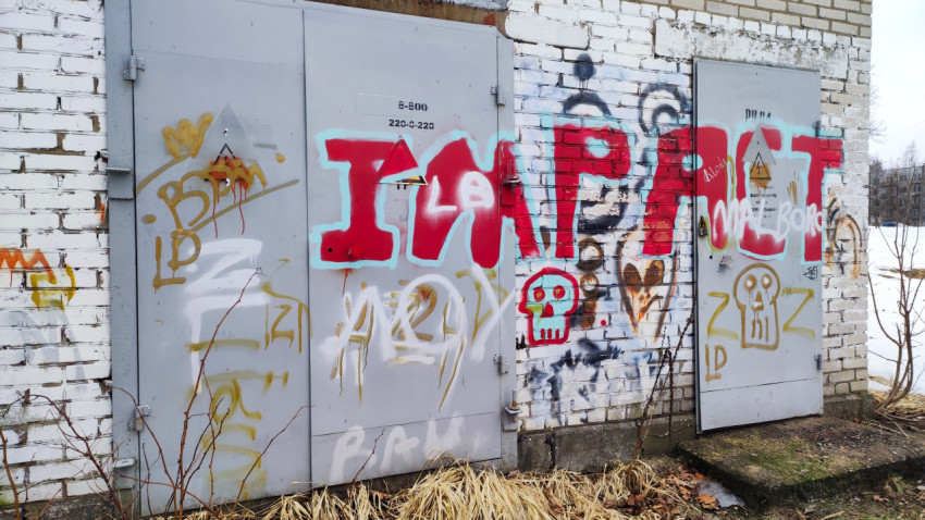 Граффити на стене кирпичного здания в зимнем дворе